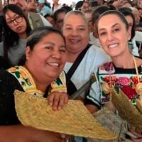 Claudia Sheinbaum entrega tarjetas de la Pensión Mujeres Bienestar durante un evento en Quiroga, Michoacán.