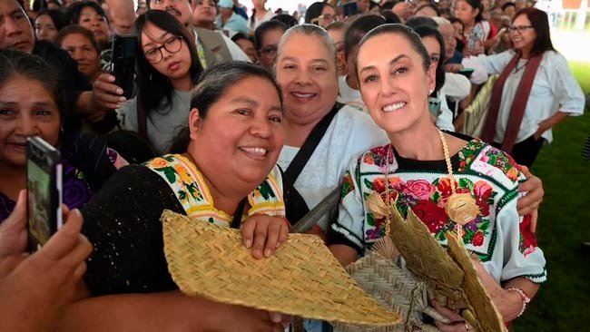 Claudia Sheinbaum entrega tarjetas de la Pensión Mujeres Bienestar durante un evento en Quiroga, Michoacán.