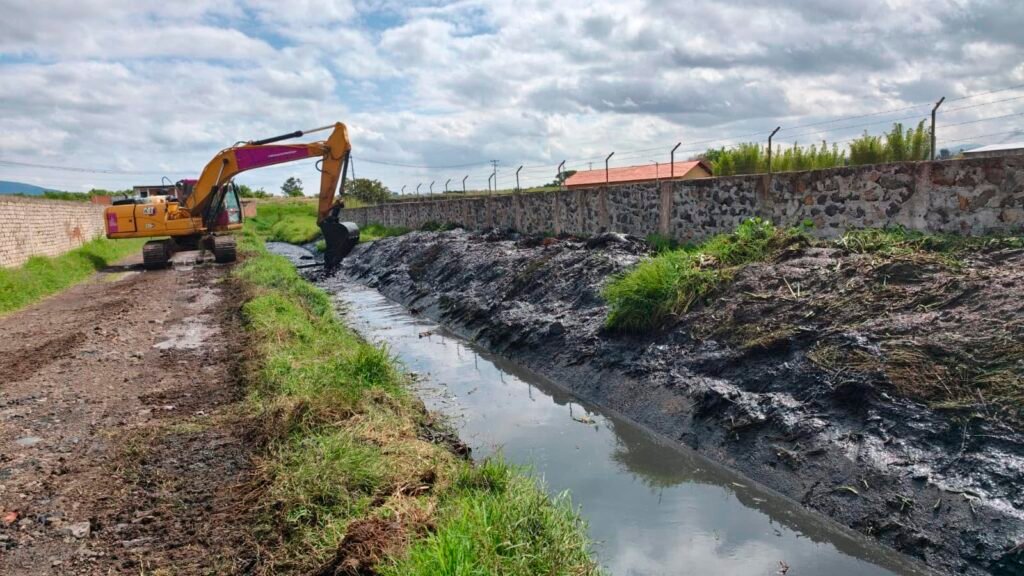 Maquinaria pesada realiza labores de desazolve y limpieza en un canal pluvial de Morelia.