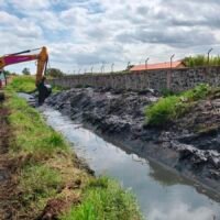 Maquinaria pesada realiza labores de desazolve y limpieza en un canal pluvial de Morelia.